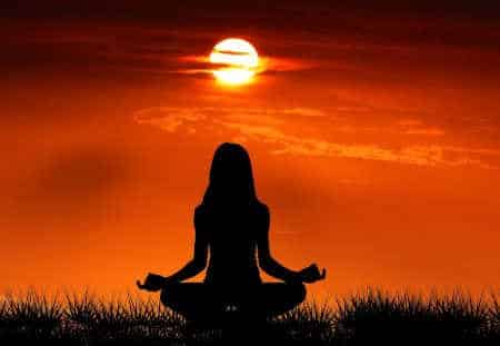 Spiritualität im Alltag Frau meditiert bei Sonnenaufgang